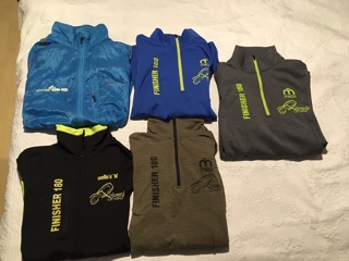 La mia collezione di maglie finisher 180: dal 2015 in alto a sinistra al 2019 tutto a destra